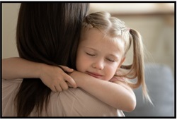 Young girl hugging an adult