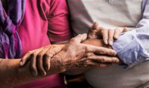 Close up view of Young Couple grasping hands with Elder Person