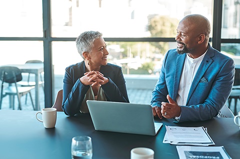 Two business people talking in an office space.